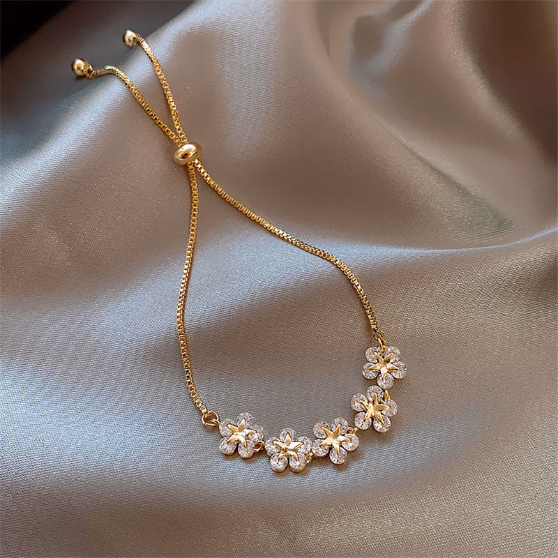 Pulsera dorada con diseño de margaritas de cristal