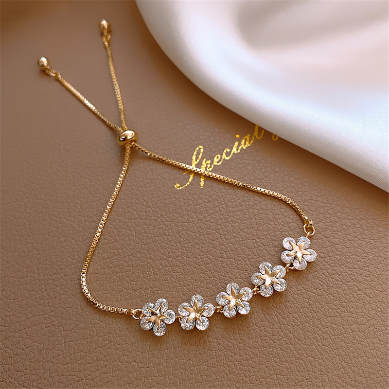 Pulsera dorada con diseño de margaritas de cristal