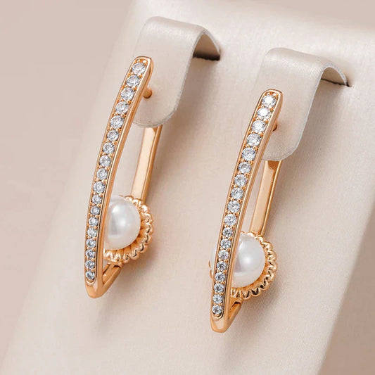 Aretes dorados elegantes con perlas y brillantes piedras de circonio