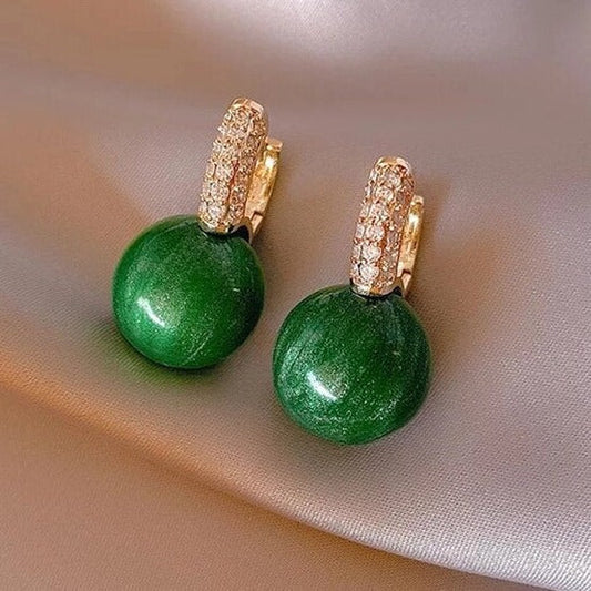 Elegantes pendientes dorados con perlas verdes