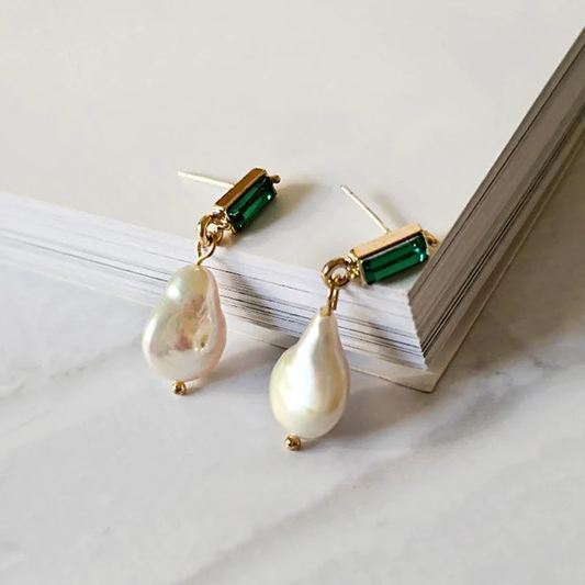 Elegantes pendientes de oro con brillantes esmeraldas y perlas resplandecientes