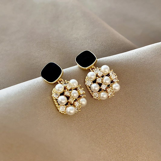 Elegantes aretes de perlas doradas con brillante ópalo negro