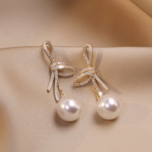 Elegantes Pendientes de Perlas Doradas con Lazo Brillante