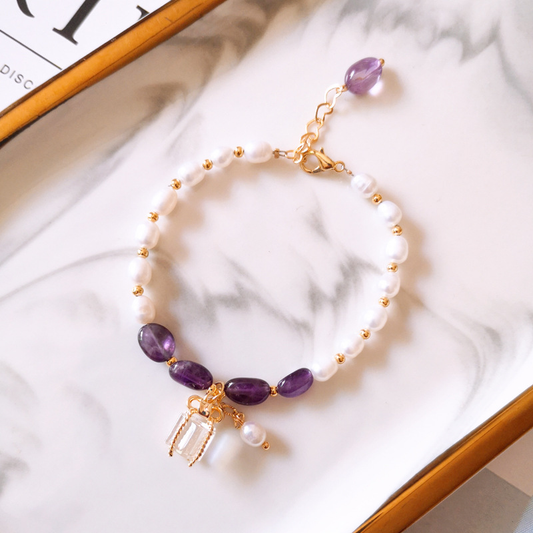 Elegante pulsera de oro con brillantes piedras moradas y perlas